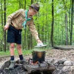 Éclaireurs cuisinant sur le feu
